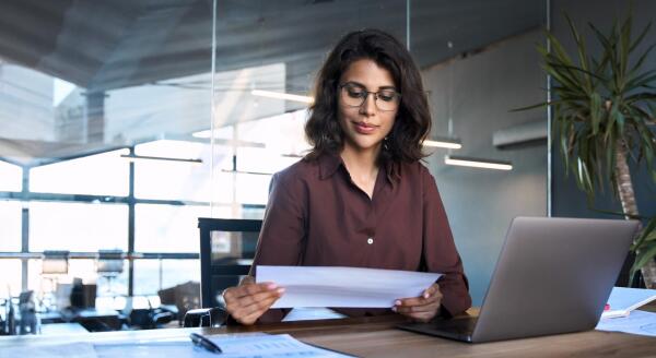 Woman reviewing documents at her computer